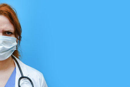 Woman doctor in a medical mask on a red background, copy space. Medic in stress, coronavirus treatment concept. Stay home.の写真素材