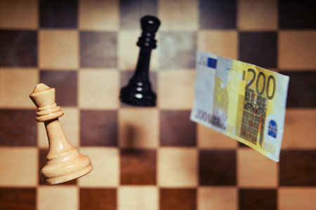 Euro money and a chessboard with chess pieces. Concept of problems of financial game, money and European economyの写真素材