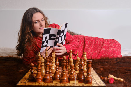 Woman learning chess from book, self study board game at homeの写真素材