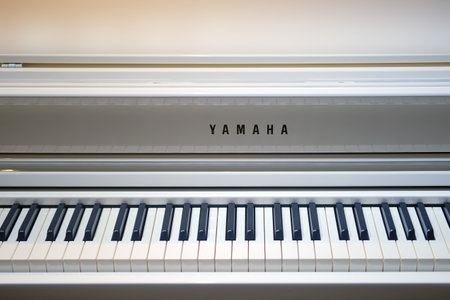 Yamaha electronic grand piano keys, white hybrid synthesizer close-up.のeditorial素材