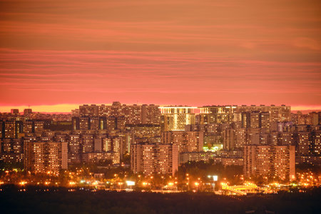 Windows of the night city building and roads with cars. Pink evening sunset over modern Moscow, Russiaの写真素材