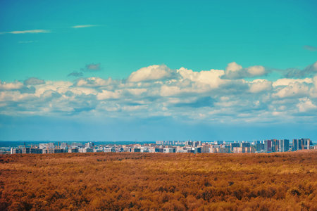 Daytime clouds against a blue sky and beautiful trees in an autumn park outside the city
