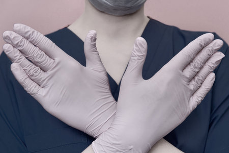 ? oncept of stay home. Hands of a medic are crossed in a sign of prohibition. Close-up of a doctor...