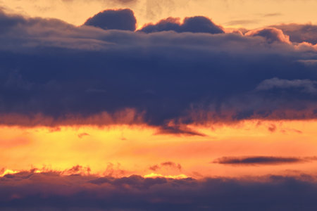 Dark clouds in the orange evening sky, sunset background