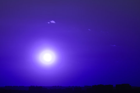 Dark blue sunset with the setting sun on the background of the night cityの写真素材