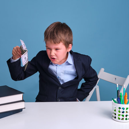 Dollars in the hands of a satisfied boy with a sly expression on his face, copy spaceの写真素材