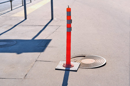 Traffic cones sign in front of a broken sewer hatch