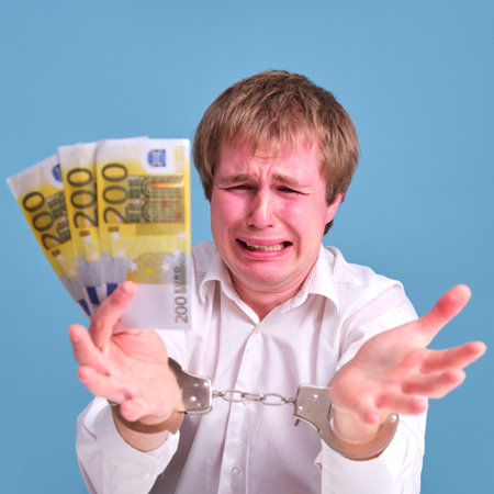 Money in the hands of a guy arrested and handcuffed, 200 eurosの写真素材