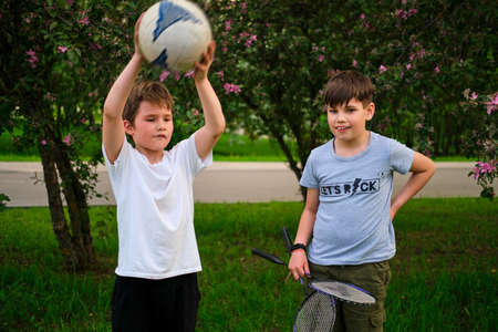 Two friends boys with tennis rackets and a ball, portrait of pre-teen childrenの写真素材