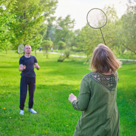 Family playing badminton in the park, mom and son with rackets and shuttlecockの写真素材