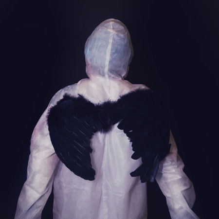Paramedic with black angel wings on his back on a dark backgroundの写真素材