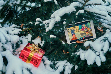 Online video conference with friends and family via tablet at the Christmas tree in the new yearの写真素材
