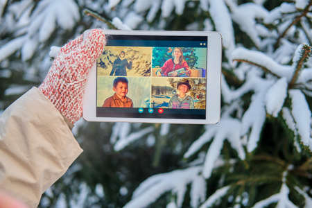 Online video conference with friends and family via tablet at the Christmas tree in the new yearの写真素材