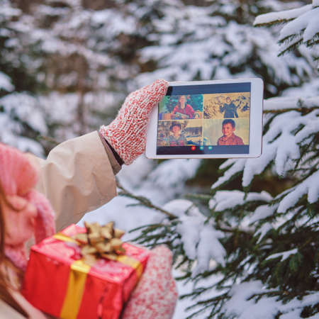 Online video conference with friends and family via tablet at the Christmas tree in the new yearの写真素材