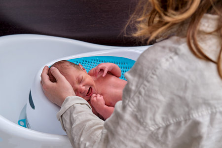 Slide for the bathroom bathing of newborn children. Parents bathe the baby in the home bathroom
