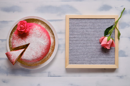 Red cake covered with marzipan with flower and sprinkled with white powdered sugar. Background for copy spaceの写真素材
