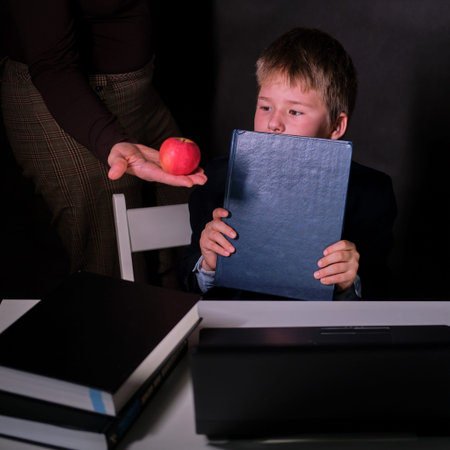 A boy in a school suit and a mother with an apple in her hand during distance learning, copy space...