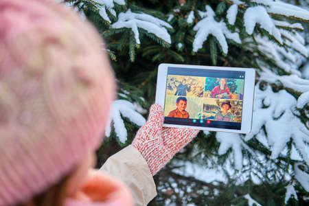 Online video conference with friends and family via tablet at the Christmas tree in the new yearの写真素材