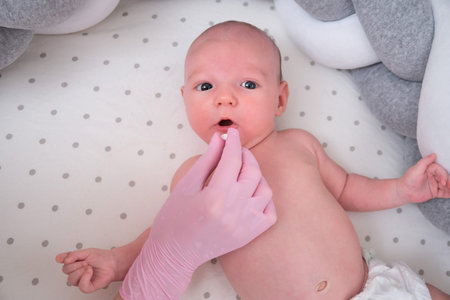 The doctor prescribes pills for a newborn child. A nurse in uniform with a medicine in her hand for...