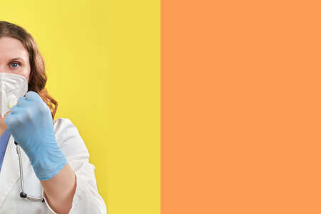 A doctor in medical gloves shows a fist, close-up. The concept of self-isolation in the case of a coronavirus pandemic and removal of quarantine - stay homeの写真素材