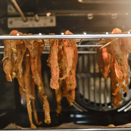 Chicken meat is drying on the grill in the oven in the home kitchen, close-upの写真素材
