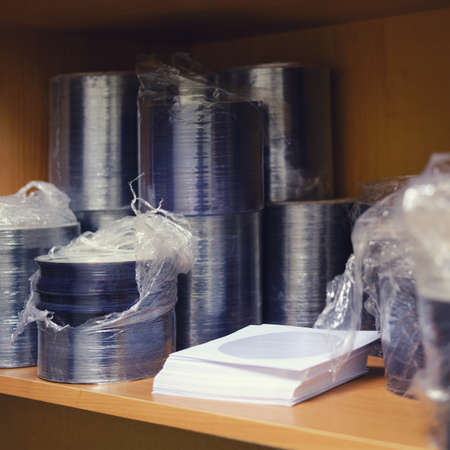 A stack of CD and DVD discs in a package on the shelfの写真素材