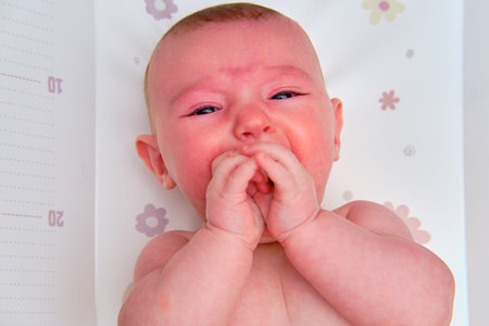 Crying Infant baby boy at the age of four months, close-up portrait