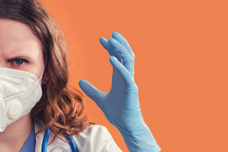 Woman doctor in a medical mask in a rage shouts on a red background, copy space. Medic in despair,...