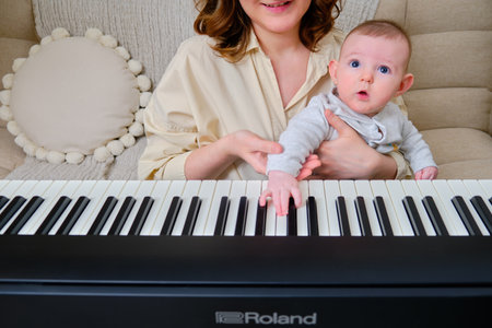 Woman musician with child teaches music on electronic piano Roland at home - Moscow, Russia, October 28, 2021のeditorial素材