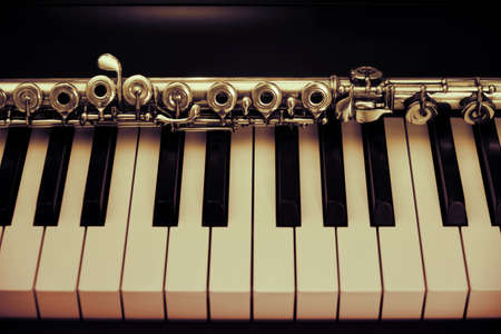 A large concert transverse flute lies on the piano keysの写真素材
