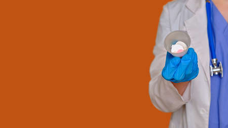 Doctor hand with pills in a container from the coronavirus epidemic, close-up. Hand in a medic, banner copy spaceの写真素材