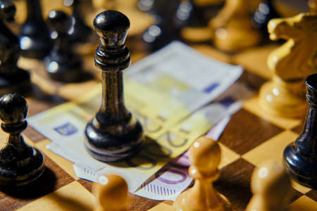 Euro money on a vintage chessboard with retro chess piecesの写真素材