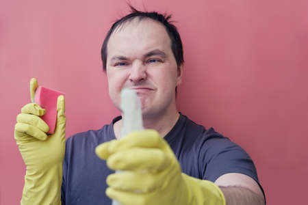 Angry man janitor in yellow gloves, studio red backgroundの写真素材