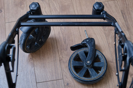 Broken chassis of a baby stroller, damage to the crossbar of the metal frame of the pram