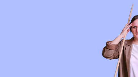 Woman teacher holding her head with her hands on studio purple background, banner copy space