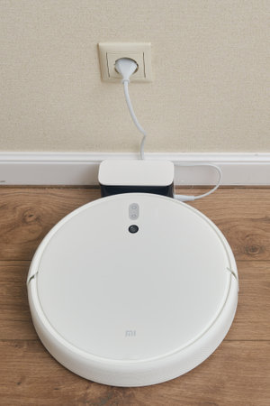 White robot cleaner Xiaomi Mi Vacuum-Mop on a wooden laminate, close-up - Moscow, Russia, March 05, 2022のeditorial素材