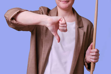 Woman teacher with thumb down gesture on studio blue background, copy spaceの写真素材