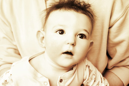 Surprised infant baby boy with big blue eyes and disheveled hair, sepia. Portrait of a frightened...