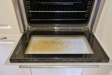 Dirty oven with grease on the glass built into the furniture in the home kitchenの写真素材