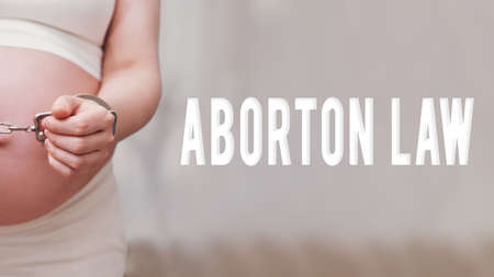The inscription abortion law and chained hands of a pregnant woman, home living roomの写真素材