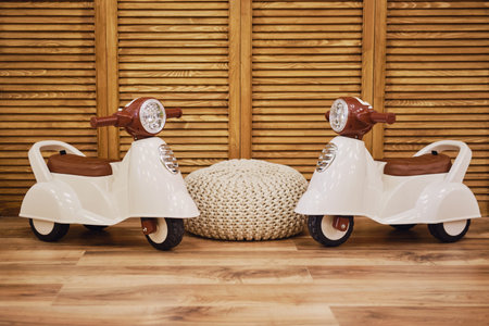 Plastic children motorcycle riding in the playroom, toy brown moped for kid