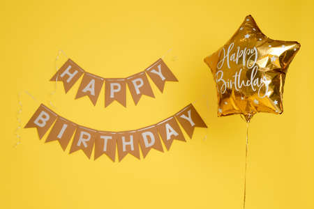 Decorations on a studio yellow background for celebrating the first birthday of a child, one year old babyの写真素材
