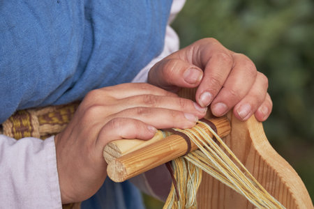 An ancient Roman woman makes yarn and sews from vintage wool. Reconstruction of the events of the Roman Empireの写真素材