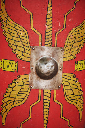 Red vintage shield of an ancient Roman warrior. Reconstruction of military events during the war of...