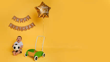 Decorations on a studio yellow background for celebrating the first birthday of a child, one year old babyの写真素材