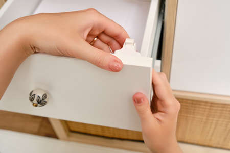 Installing a child-proof magnetic lock to protect cabinet doors and drawers of home furnitureの写真素材
