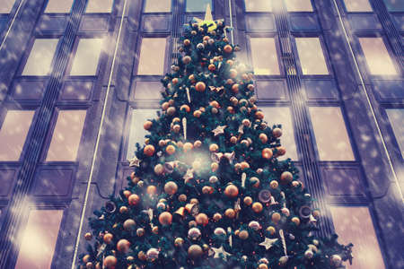 Golden snow balls and bubbles on green Christmas trees as an element of decoration buildings for the new yearの写真素材