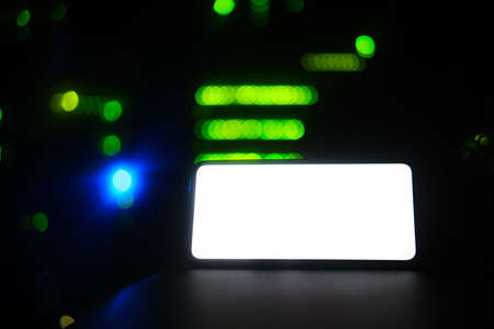 An empty form with a background on the phone screen, copy space. Smartphone on the background of a dark server room, mockupの写真素材