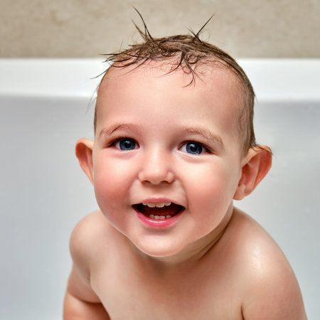 Portrait of a washing toddler baby boy in the bath, happy child. Smiling face of a child with wet...
