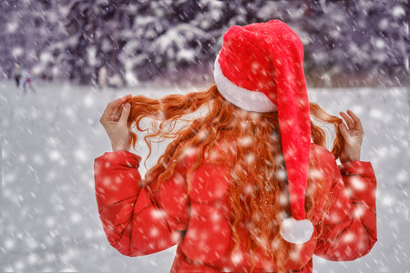 A happy woman stands with a red umbrella in her hands, a winter park with snow-covered trees